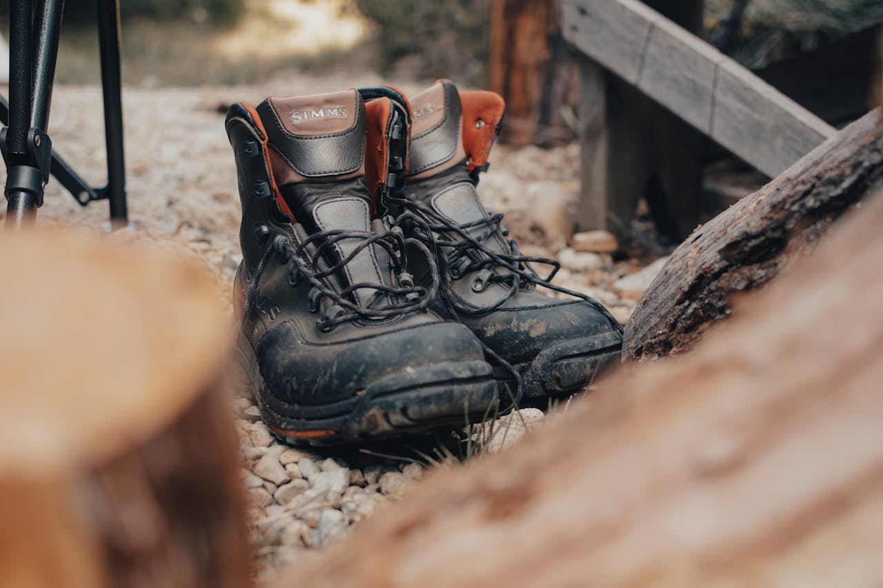 Close-up of durable hiking boots on rocky ground, ideal for outdoor adventures.